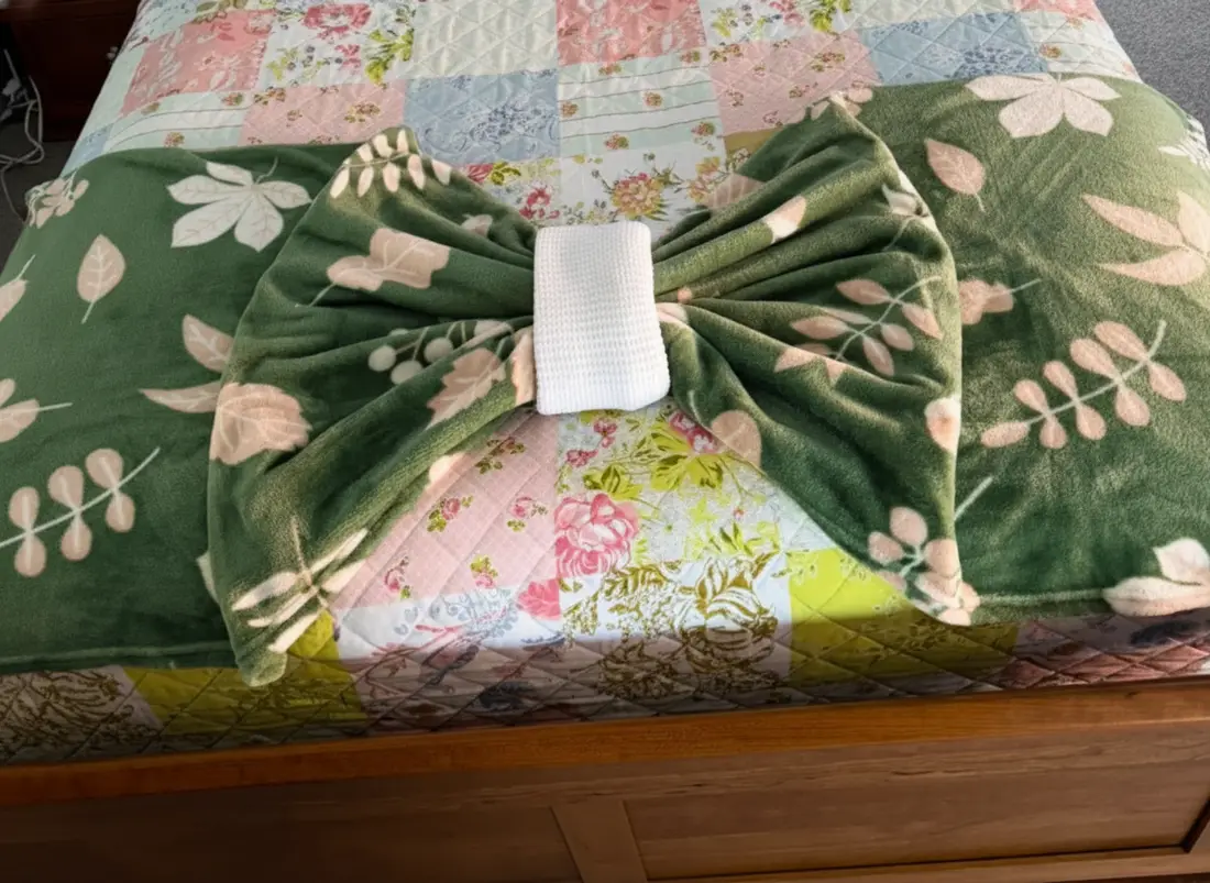 Neatly made bed with smoothed bedding after a house cleaning