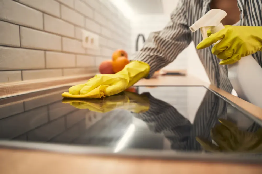 Gloved hand wiping a kitchen surface during a house cleaning in New Bedford